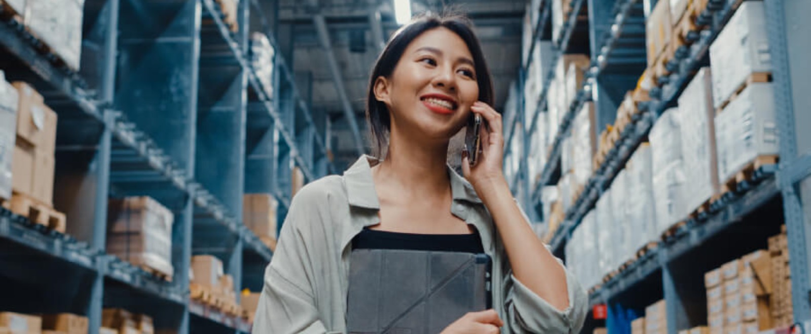 a warehouse working on her mobile phone
