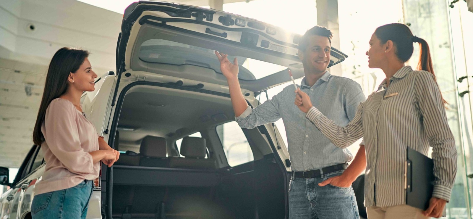 a couple looking at new automobiles with a sales rep